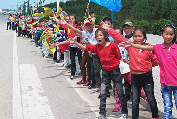 Children cheer on runners as the distant finish line inches closer. [Photo: CRIENGLISH.com/William Wang]