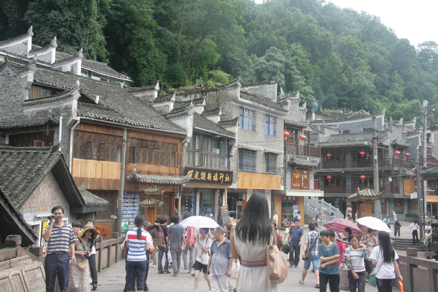 Visitors tour a commercial street in Fenghuang (Phoenix) ancient town on June 28. [CnDG by Jiao Meng]