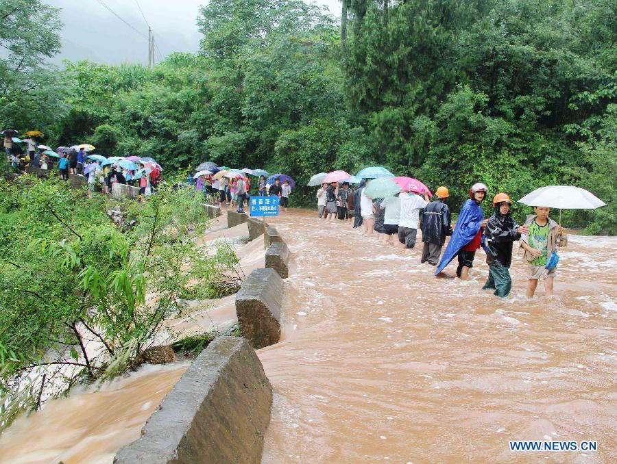 Trapped students are transfered in Banbianjie Village of Qinhe Township in Dazhou, southwest China's Sichuan Province, July 4, 2012. 