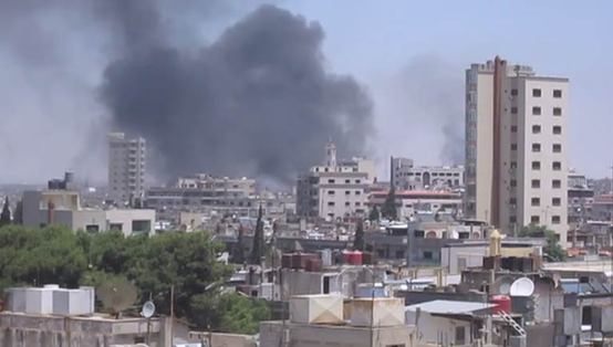 In Homs, Syria, smoke drifts into the sky from buildings and houses hit by shelling. [UNSMIS]