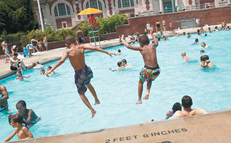 Two boys jump into a pool at the Hamilton Fish Recreation Center in the Lower East Side neighborhood of New York on Saturday. Temperatures were supposed to reach 38 C. [Agencies]