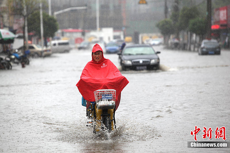 Rainstorms hit Lianyungang, Jiangsu Province, on July 8, 2012. In the picture people try to float across a street which is flooded during the rainstorms. 