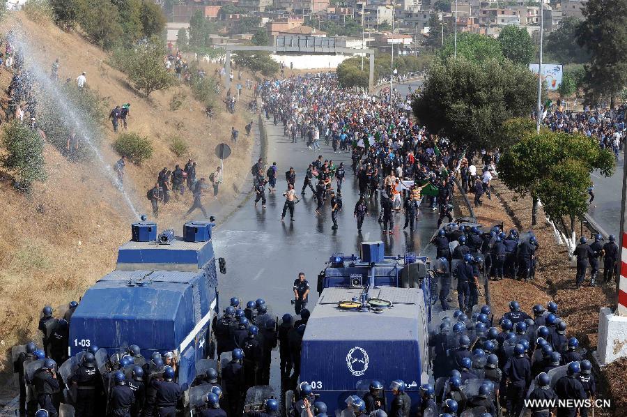 Riot police clash with community police during a demonstration in the neighbourhood of Bir Khadem in southern Algiers, capital of Algeria, on July 9, 2012. At least 5,000 members of the community police tried to go to the Presidency of the Republic to demand more socio-professional rights from the government. (Xinhua/Mohamed Kadri) 