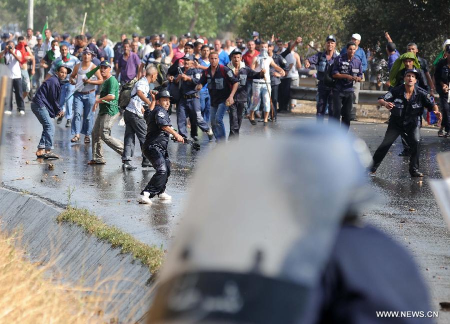 Riot police clash with community police during a demonstration in the neighbourhood of Bir Khadem in southern Algiers, capital of Algeria, on July 9, 2012. At least 5,000 members of the community police tried to go to the Presidency of the Republic to demand more socio-professional rights from the government. (Xinhua/Mohamed Kadri) 