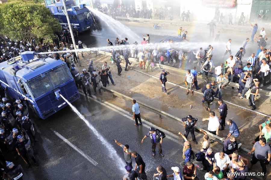 Riot police clash with community police during a demonstration in the neighbourhood of Bir Khadem in southern Algiers, capital of Algeria, on July 9, 2012. At least 5,000 members of the community police tried to go to the Presidency of the Republic to demand more socio-professional rights from the government. (Xinhua/Mohamed Kadri) 