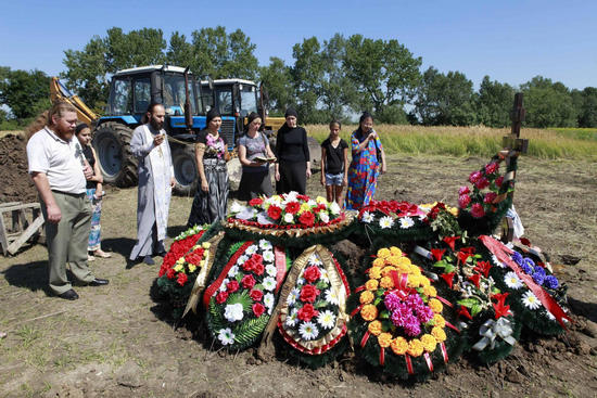 Acquaintances of Pyotr Ostapenko, 35, a flood victim, take part in a funeral ceremony at the central cemetery of the town of Krymsk in the Krasnodar region, southern Russia, July 9, 2012. [Photo/Agencies]