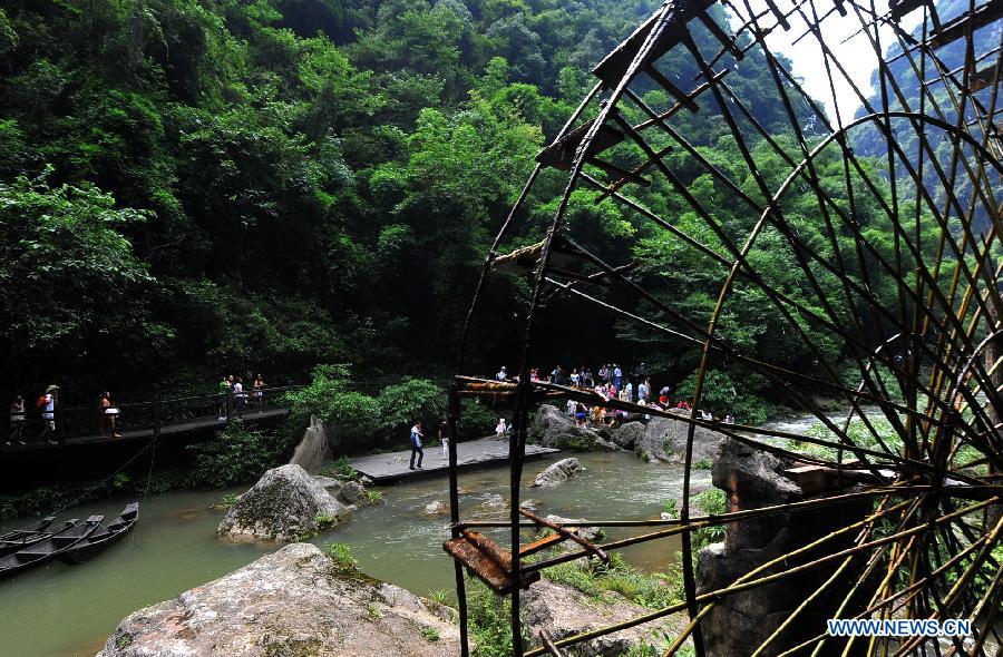 Tourists visit a sight-seeing resort in the Xiling Gorge, the easternmost of the Three Gorges along the Yangtze River, in Yichang, central China's Hubei Province, July 8, 2012. Tourism revenue has soared in recent years as the resort incorporated both natural scenery and local ethnic culture in its operation. (Xinhua/Chen Haining) 