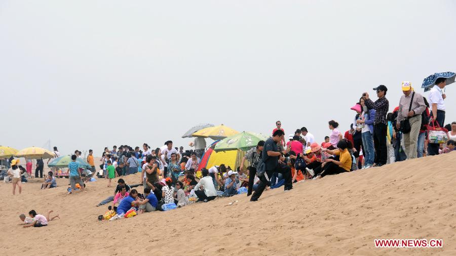 Tourists visit the Sand Lake scenic area in Pingluo County, northwest China's Ningxia Hui Autonomous Region, July 8, 2012. Scenic spots in the deserts of Ningxia have entered the high season of tourism in recent days. [Xinhua/Li Ran] 