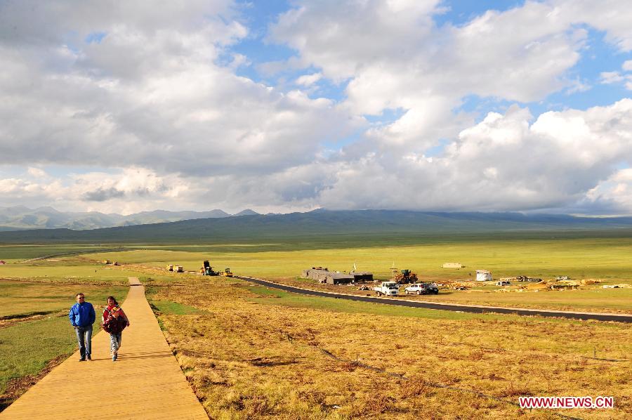 Tourists visit the Bayan Bulag grassland in Hejing County, northwest China's Xinjiang Uygur Autonomous Region, July 5, 2012. Xinjiang entered the peak season for summer tourism recently with glamorous sceneries of snowy mountains, deserts, lakes and pastures. (Xinhua/Zhang Jiansong) 