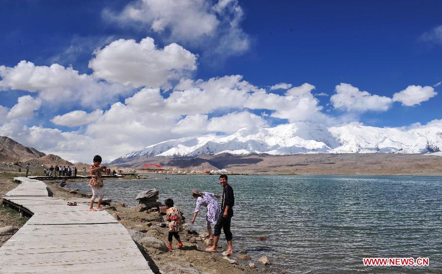 Tourists visit the Karakol Lake, northwest China's Xinjiang Uygur Autonomous Region, July 2, 2012. Xinjiang entered the peak season for summer tourism recently with glamorous sceneries of snowy mountains, deserts, lakes and pastures. (Xinhua/Zhang Jiansong) 