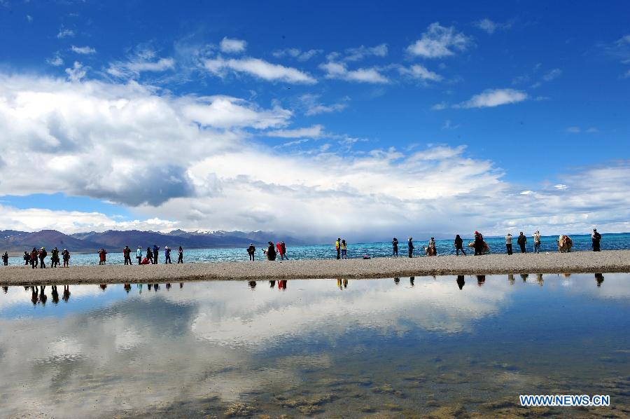 Tourists visit Nam Co Lake, the highest saltwater lake of the world at 4,718 meters above the sea level, located at the boundary of Damxung and Baingoin counties, southwest China's Tibet Autonomous Region, July 6, 2012. 