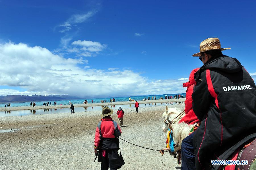 Tourists visit Nam Co Lake, the highest saltwater lake of the world at 4,718 meters above the sea level, located at the boundary of Damxung and Baingoin counties, southwest China's Tibet Autonomous Region, July 6, 2012. 