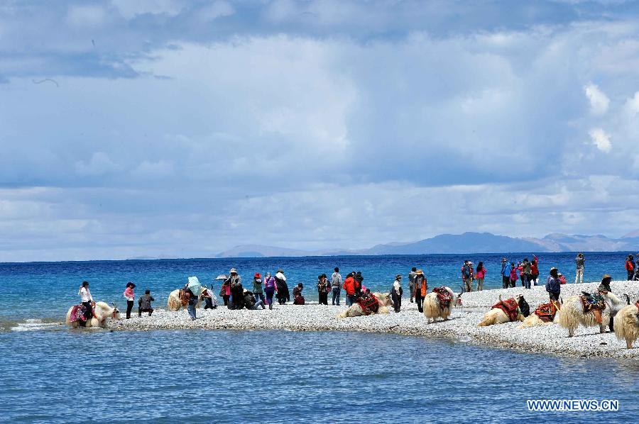 Tourists visit Nam Co Lake, the highest saltwater lake of the world at 4,718 meters above the sea level, located at the boundary of Damxung and Baingoin counties, southwest China's Tibet Autonomous Region, July 6, 2012. 