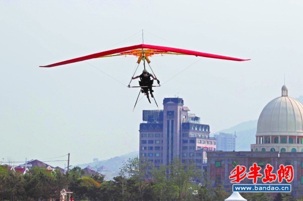 China&apos;s 1st hang gliding man flies over Jiaozhou Bay