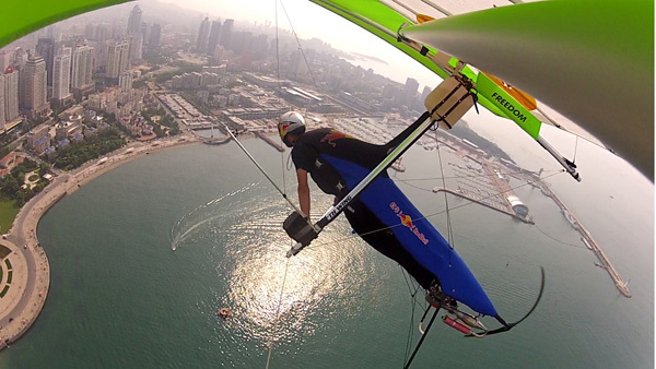 China&apos;s 1st hang gliding man flies over Jiaozhou Bay