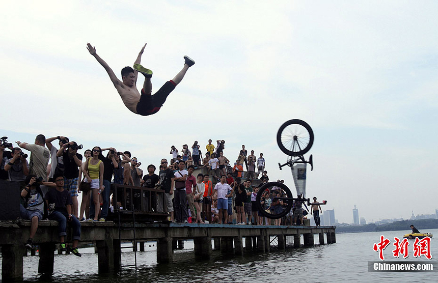 A man in Wuhan, Hubei Province, jumps into the lake to escape from the heat on July 9. Many areas of China are suffering continuous rainstorms. Meanwhile, sizzling heat is sweeping some other areas of the country. 