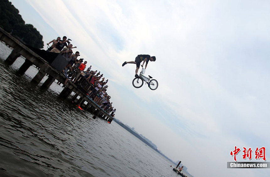 A man in Wuhan, Hubei Province, jumps into the lake to escape from the heat on July 9. Many areas of China are suffering continuous rainstorms. Meanwhile, sizzling heat is sweeping some other areas of the country. 