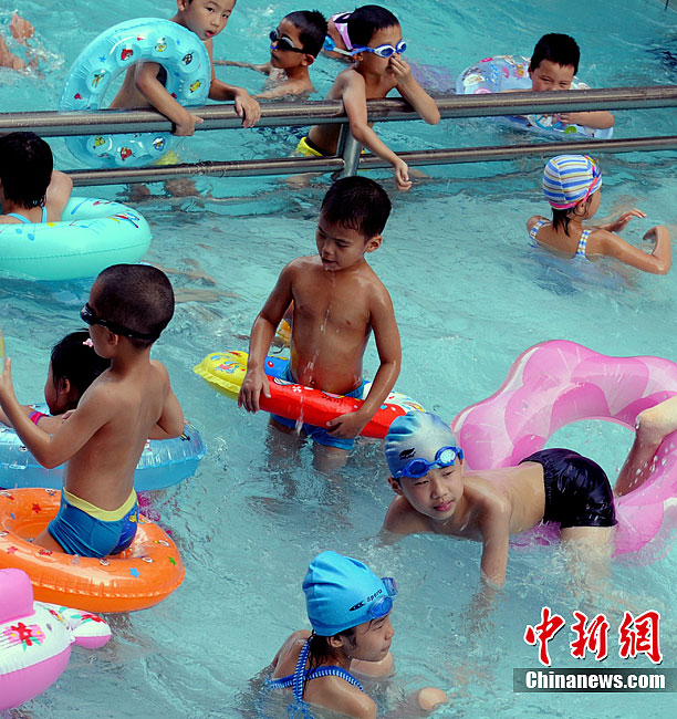 Children are playing about in a swimming pool in Fuzhou, Fujian, on July 9. Many areas of China are suffering continuous rainstorms. Meanwhile, sizzling heat is sweeping some other areas of the country. 