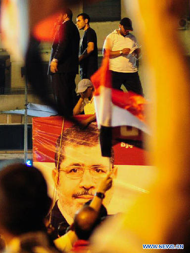 A picture of Egypt's President Mohamed Mursi is seen on a vehicle as his supporters gather at Cairo's Tahrir Square in Egypt, July 10, 2012. Egypt's Supreme Constitutional Court on Tuesday suspended a presidential decree reinstating the dissolved People's Assembly (lower house of parliament). [Qin Haishi/Xinhua] 