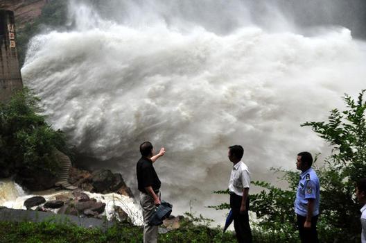 Staff members check the operation of the floodgates at the Erlang Dam in Ningqiang County, Hanzhong City of China's Shaanxi Province, July 9, 2012. [Xinhua] 