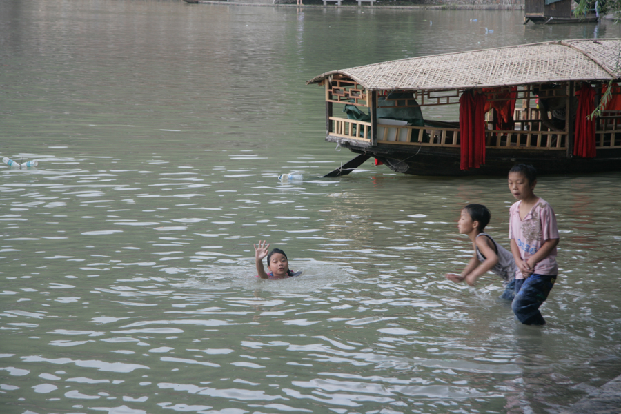 Children swim in the river to keep cool in Biancheng Town. [CnDG by Jiao Meng]