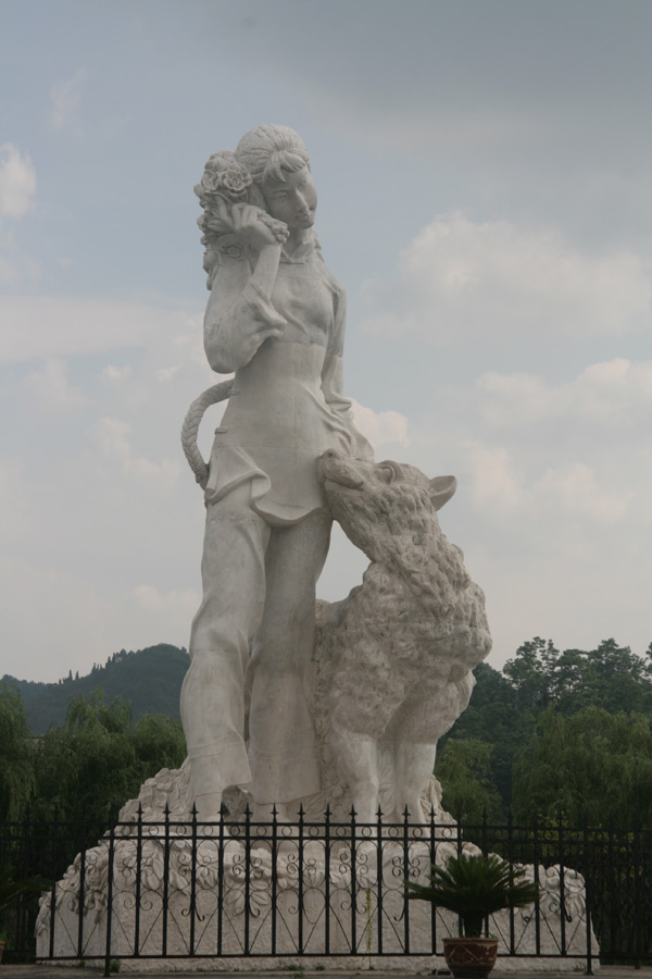 Created by artist Huang Yongyu, the sculpture of Cuicui and her dog stands at the riverbank and still waits for her lover Nuosong. [CnDG by Jiao Meng]