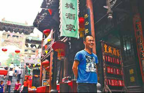 Yan Shaobo stands in front of his restaurant in Huangcheng village.