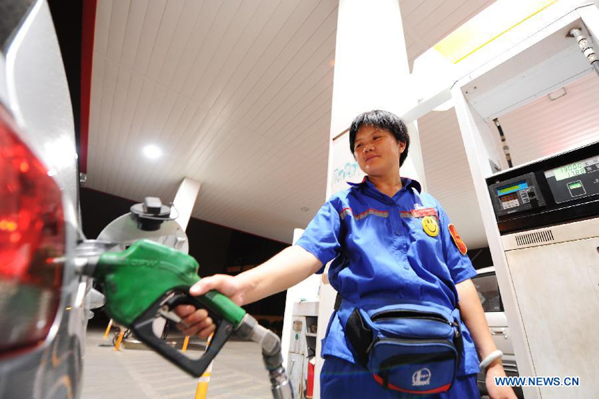 A staff member of a gas station fills a car with fuel just after fuel price cut in Hefei, capital of east China's Anhui Province, July 11, 2012. China slashed the benchmark retail price for gasoline by 420 yuan (66.46 U.S. dollars) per metric ton (tonne) and the price for diesel by 400 yuan per tonne starting from Wednesday. The decreases mark the third fuel price cut in two months, as crude oil costs have continued to fall since China's most recent price cuts in June.