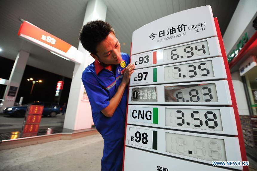 A staff member of a gas station alters fuel price tags in Hefei, capital of east China's Anhui Province, July 11, 2012. China slashed the benchmark retail price for gasoline by 420 yuan (66.46 U.S. dollars) per metric ton (tonne) and the price for diesel by 400 yuan per tonne starting from Wednesday. The decreases mark the third fuel price cut in two months, as crude oil costs have continued to fall since China's most recent price cuts in June.