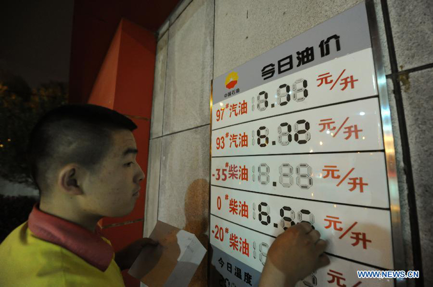 A staff member of a gas station alters fuel price tags in Changchun, capital of northeast China's Jilin Province, July 11, 2012. China slashed the benchmark retail price for gasoline by 420 yuan (66.46 U.S. dollars) per metric ton (tonne) and the price for diesel by 400 yuan per tonne starting from Wednesday. The decreases mark the third fuel price cut in two months, as crude oil costs have continued to fall since China's most recent price cuts in June. 