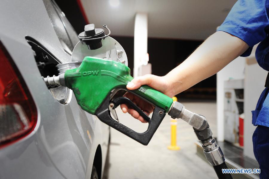 A staff member of a gas station fills a car with fuel just after fuel price cut in Hefei, capital of east China's Anhui Province, July 11, 2012. China slashed the benchmark retail price for gasoline by 420 yuan (66.46 U.S. dollars) per metric ton (tonne) and the price for diesel by 400 yuan per tonne starting from Wednesday. The decreases mark the third fuel price cut in two months, as crude oil costs have continued to fall since China's most recent price cuts in June. 