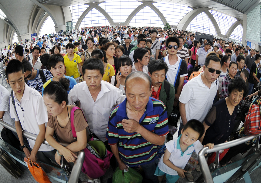 Passengers are examined tickets in the Yinchuan Railway Station on July 11. The volume of passenger traffic reaches its climax as school vacation and summer workers recruiting start in July. [Xinhua photo] 