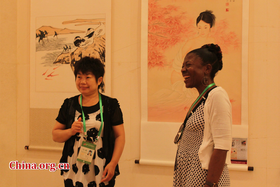 Two delegates are taking pictures at the photo exhibition. The 2012 China-Africa People's Forum opens on July 10th in Suzhou, southeast China. Besides a plenary session and three panel meetings, there was also a photo exhibition on China-Africa friendship to showcase China and Africa's very different yet equally colorful cultures.