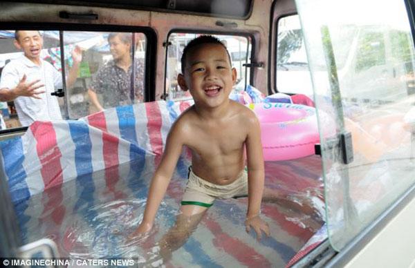 Zhou Yuhang, six, can escape the soaring temperatures in east China's Zhejiang province even while on the move, after his father converted a van into a mobile paddling pool.