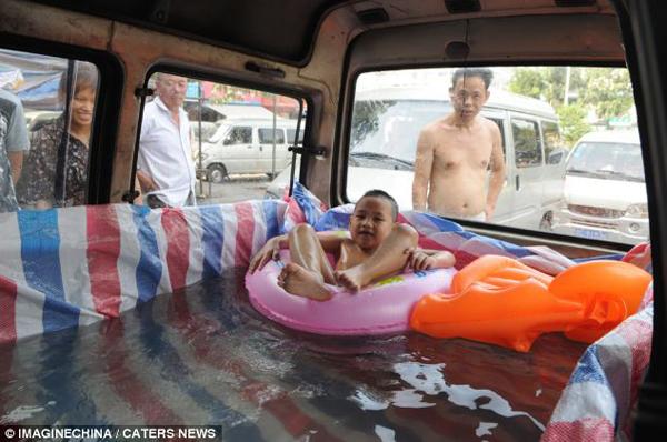 The six-year-old floats on an inflatable ring in his private 'pool' while his family look on.