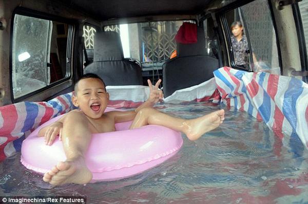 Sweltering temperatures across east China's Zhejiang province show no signs of abating, but Zhou Yuhang can keep cool even while on the move after his father transformed his van into a paddling pool. 