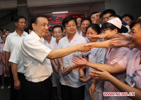 Chinese Vice Premier Li Keqiang (L, front) visits a hospital in Hong'an County, central China's Hubei Province, July 14, 2012. Li made an inspection tour in Hubei from July 13 to 14. [Xinhua]