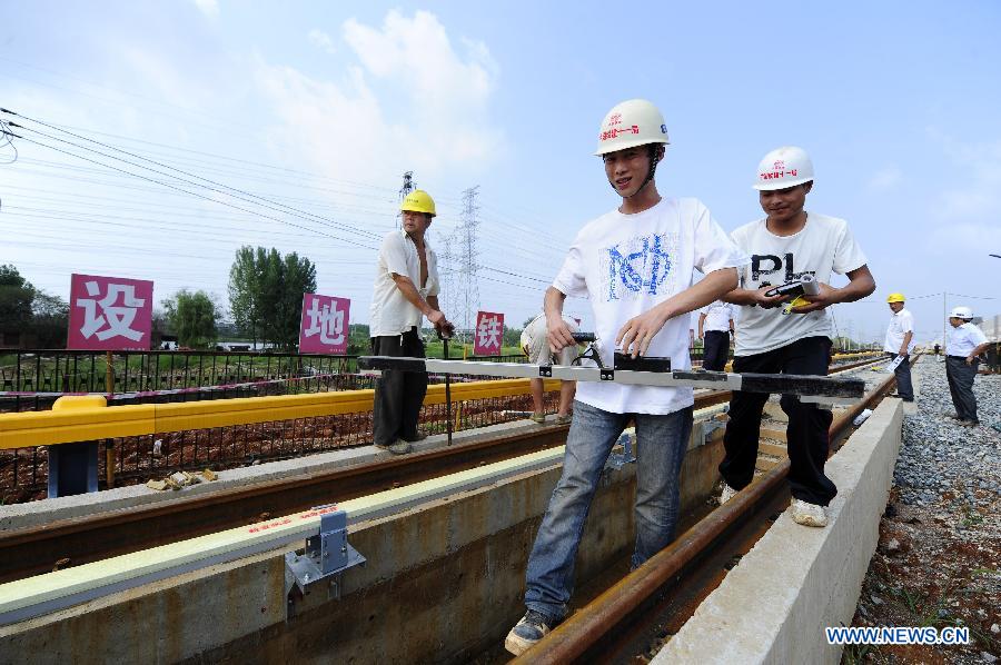 Workers are seen at the Changqing depot of Wuhan Subway Line No. 2 in Wuhan, capital of central China's Hubei Province, July 14, 2012. The Line No. 2 is the first subway line of the city, also the first subway line across the Yangtze River. The construction of the project started in 2006. It is expected to be put into operation in the end of 2012. 