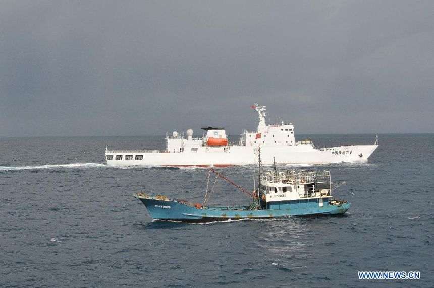 A fishery administration ship (Top) assists a fishing vessel near Yongshu Reef of Nansha Islands, south China Sea, July 15, 2012. A fleet of 30 fishing vessels arrive at Yongshu Reef of south China Sea on Sunday. The fleet, departing from Sanya City of south China's Hainan Province on July 12, 2012, will spend 20 days fishing near the Yongshu Reef, sailors of the fleet said.