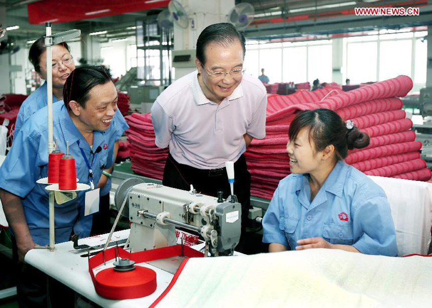 Chinese Premier Wen Jiabao (C) talks to workers in a workshop of the Rainbow Appliance Group in Chengdu, capital of southwest China's Sichuan Province, July 14, 2012. Wen Jiabao made an inspection tour of Sichuan Province from July 13 to 15.