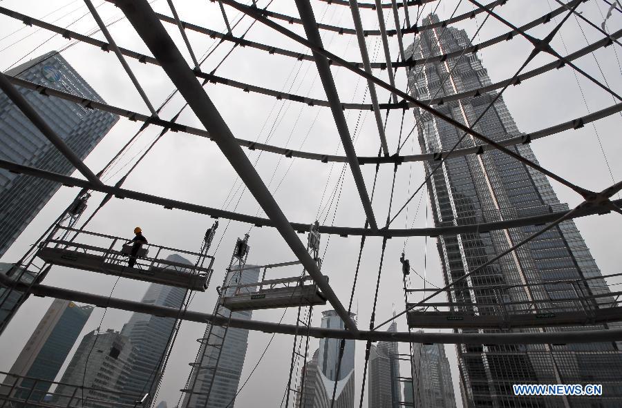 Workers joins in the installation of curtain walls for the Shanghai Tower under construction in the Pudong District of east China's Shanghai, July 15, 2012. The Shanghai Tower, to be the tallest building in Shanghai upon completion, started to be installed with curtain walls in recent days.