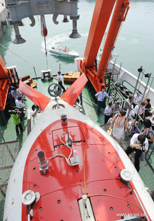 People visit the Xiangyanghong-9 ship which carries China's manned submersible Jiaolong in Qingdao, east China's Shandong Province, July 16, 2012. China's manned submersible Jiaolong has successfully completed its program of deep sea dives, with a sixth and final dive to 7,000 meters in the Mariana Trench in the Pacific Ocean on June 30.