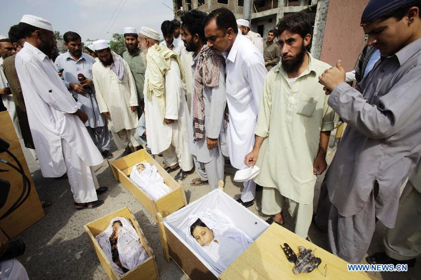 Pakistani people attend a funeral procession of three children, killed after a mortar bomb in a house, in northwest Pakistan's Peshawar on July 15, 2012. A mortar bomb smashed through a house at a village in northwestern Pakistan early Sunday, killing three children and their mother and injuring their father, police said.