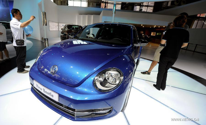 A visitor takes photos of the newly designed Volkswagen Beetle presented in the 9th China (Changchun) International Automobile Expo in Changchun, capital of northeast China's Jilin Province, July 16, 2012. The new Beetle is expected to go on sale officially in this autumn with a price of 200,000 - 300,000 yuan (about 31,340-47,010 U.S. dollars). 