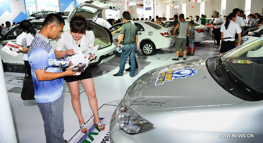 A man learns information about car performance during the 9th China (Changchun) International Automobile Expo in Changchun, capital of northeast China's Jilin Province, July 16, 2012. 