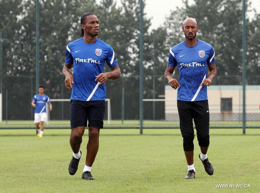 Shanghai Shenhua player Didier Drogba (L) and Nicolas Anelka attend a training session in Shanghai, China, July 16, 2012. Drogba signed a two-a-half-year contract with Shanghai Shenhua FC, which is expected to make him one of football's highest-paid players.(Xinhua/FanJun) 