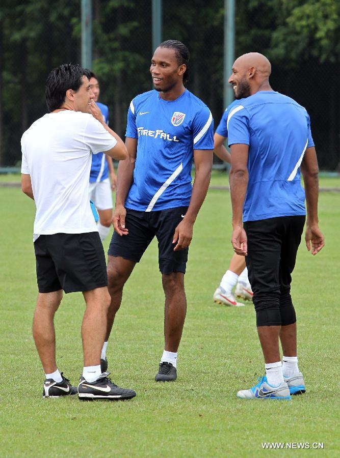 Shanghai Shenhua player Didier Drogba (C) and Nicolas Anelka (R) attend a training session in Shanghai, China, July 16, 2012. Drogba signed a two-a-half-year contract with Shanghai Shenhua FC, which is expected to make him one of football's highest-paid players.(Xinhua/FanJun) 