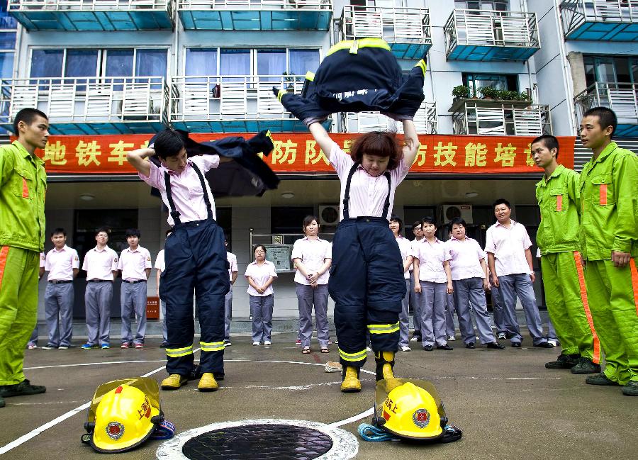 A metro staff member practices using fire hoses in Shanghai, east China, July 17, 2012. Firefighters of Huangpu District provided a fire safety training to over 600 fire fighting volunteers of Shanghai Metro on Tuesday, to enhance those metro staff's emergency response capability. (Xinhua/Chen Fei) 