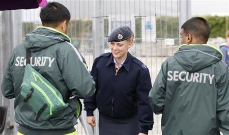 A member of the RAF checks the identifications of two G4S security guards at an exit to the Olympic Park in Stratford, the location of the London 2012 Olympic Games, in east London July 15, 2012.