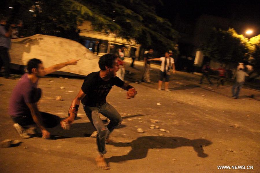 Egyptian protesters clash with riot police after a protest demanding expulsion of the Syrian ambassador near the Syrian embassy in Cairo, Egypt on July 18, 2012. Dozens of protesters were wounded and at least 14 police soldiers were injured during the clashes. (Xinhua/Amru Salahuddien) 